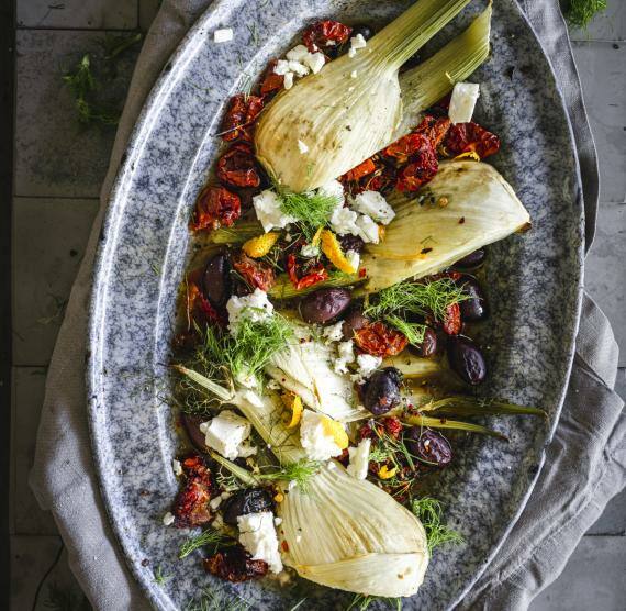 Tablett mit Fenchel, getrockneten Tomaten, Oliven, Kräutern, Feta und abgeriebener Orangenschale