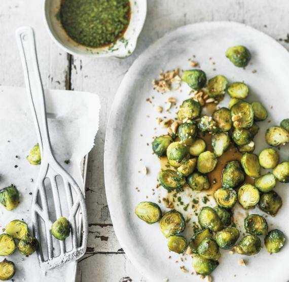 Tablett mit gebackenem Rosenkohl, daneben Marinade mit gehacktem Koriander