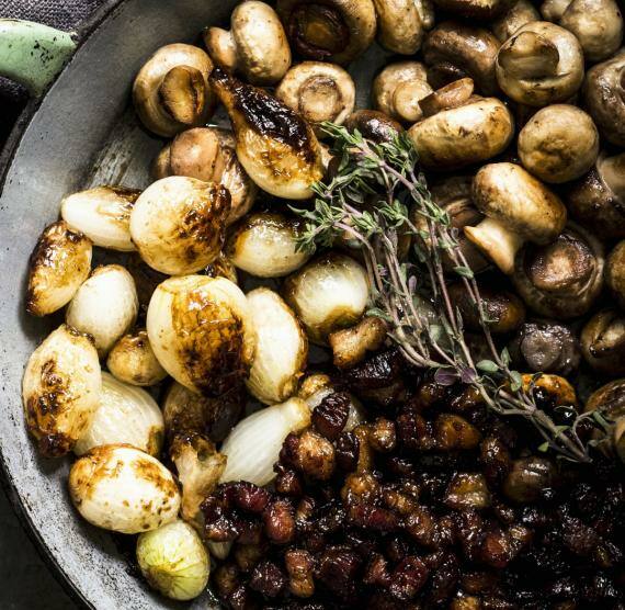 Pfanne mit ganzen Champignons und Kräutern