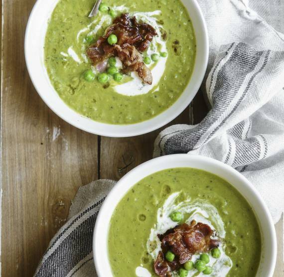 Erbsensuppe in zwei hellen Schüsseln auf einem rustikalen Holzstisch