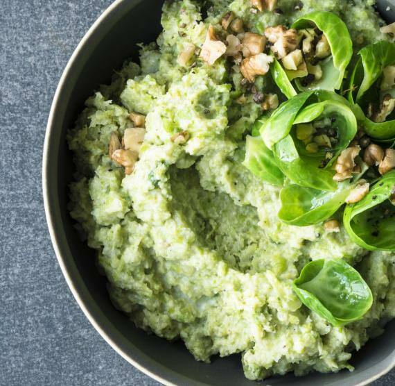Rosenkohlpüree in einer Schale mit gehackten Walnüssen