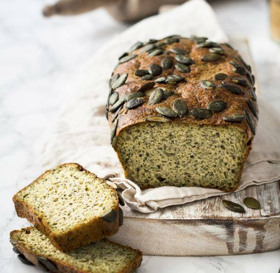 Aufgeschnittenes Kürbistoasrbrot mit Kürbiskernen auf hellem Untergrund