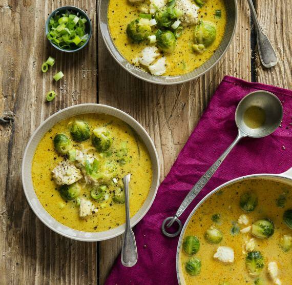 Schalen mit gelbem Curry, Fisch und Rosenkohl