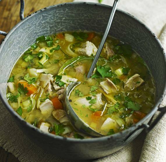 Hühnersuppe in einem großen, alten Topf mit Schöpfkelle