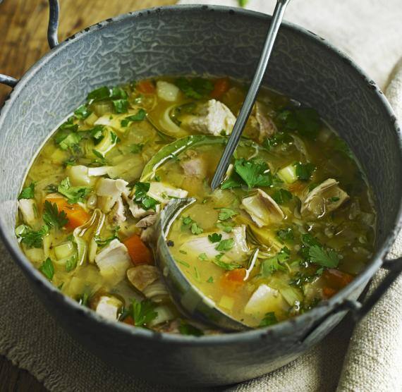 Hühnersuppe in einem großen, alten Topf mit Schöpfkelle