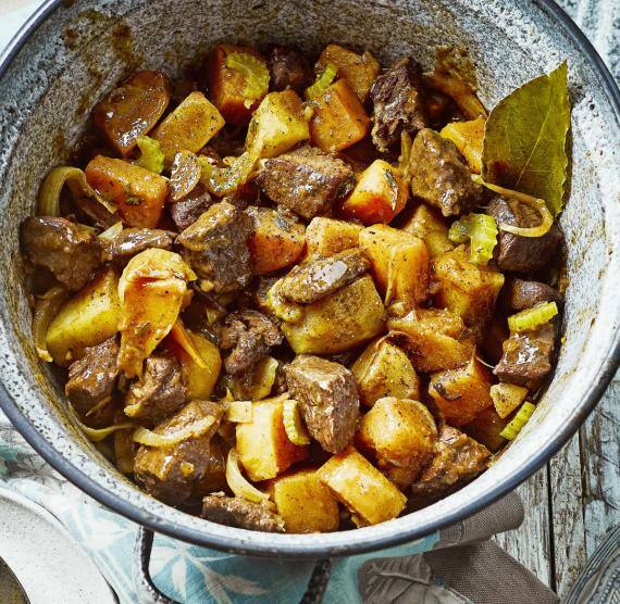 Topf mit Rindereintopf mit Gemüse kleiner Teller mit Löffel und mit dem Eintopf