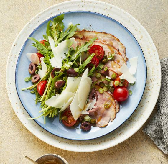 Mediterraner Roastbeef-Salat mit Pecorino auf einem hellblauen Teller mit Dressing