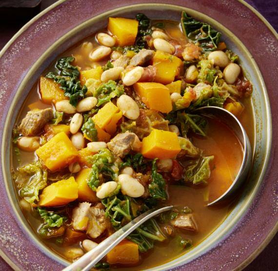 Kürbiseintopf mit Wirsing und Bohnen in einem Teller mit Löffel