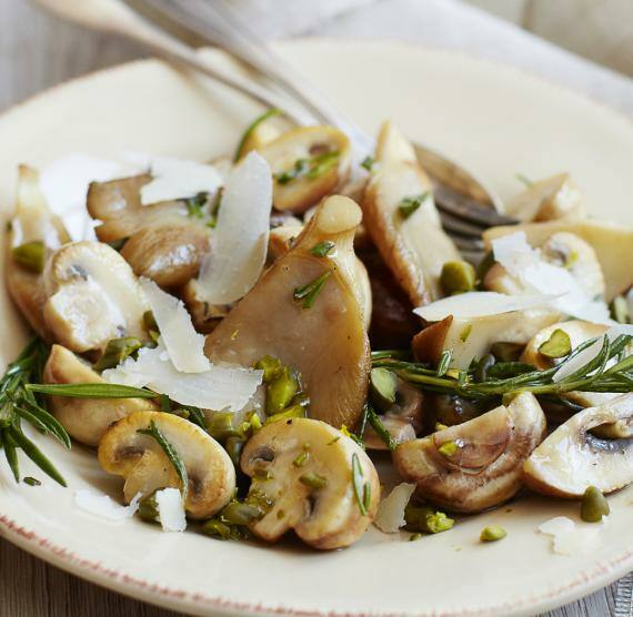 Pilzsalat mit Pistazien und Rosmarin auf Teller