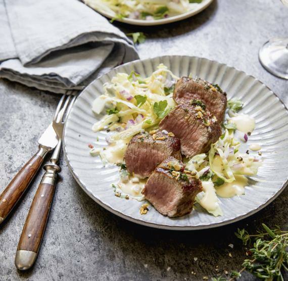 Teller mit Lammfilets und cremigem Spitzkohlsalat