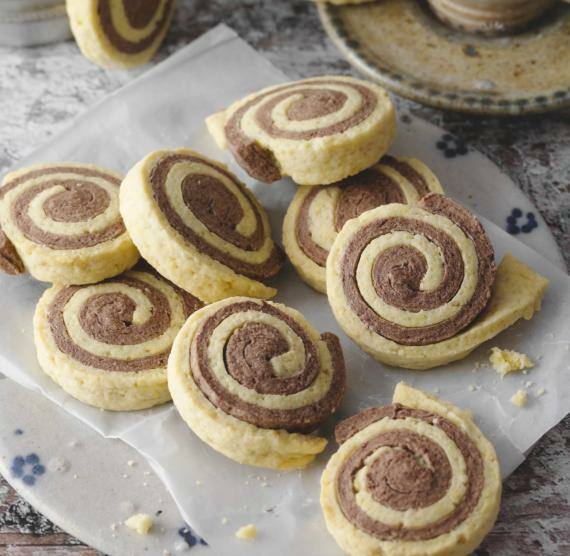 Runde Kekse aus hellen und dunklen teigbahnen auf einem Teller