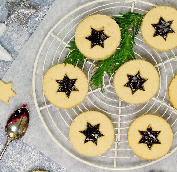 Spitzbuben auf einem Kuchengitter auf dem Tisch mit Deko