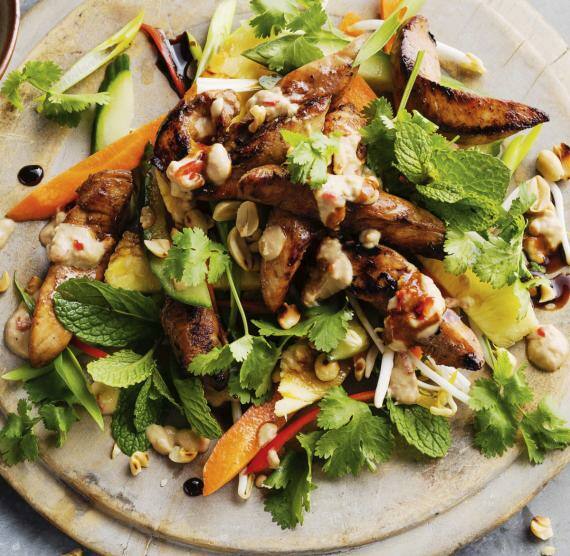 Salat auf Brett mit Hähnchen, Gurke, Karotte und Ednüssen