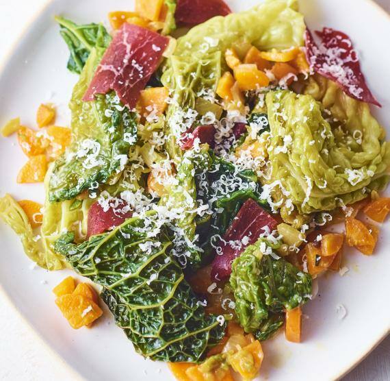 Grünkohl und Gemüse auf einem Teller mit Parmesantopping