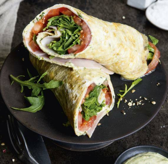 Wraps mit Tomaten, Schinken und Rucola auf Teller