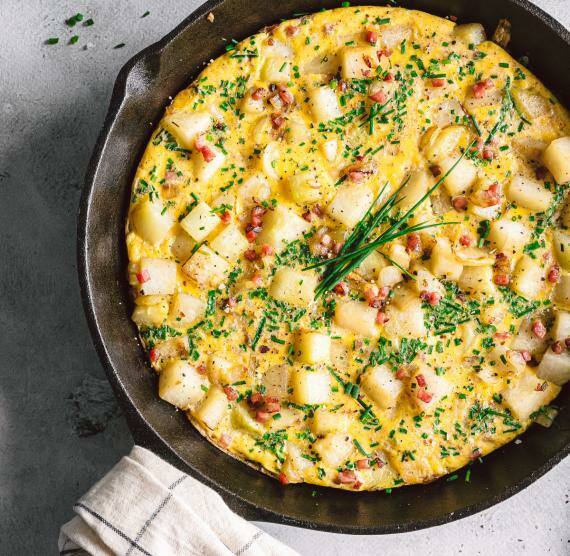 Bauernfrühstück in einer tiefen Gusseisen-Pfanne