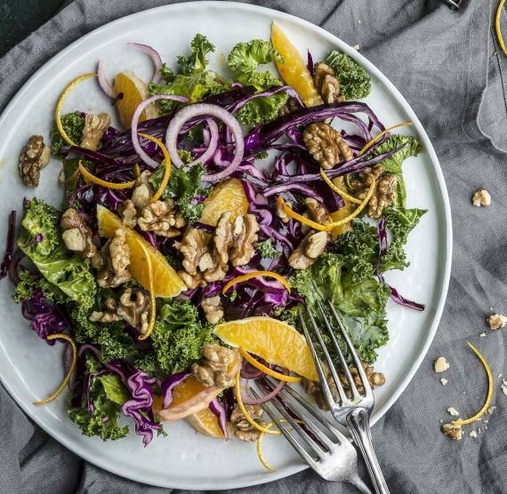 Salatteller mit Grünkohl, Rotkohl, roten Zwiebeln, Orangen und Walnüssen