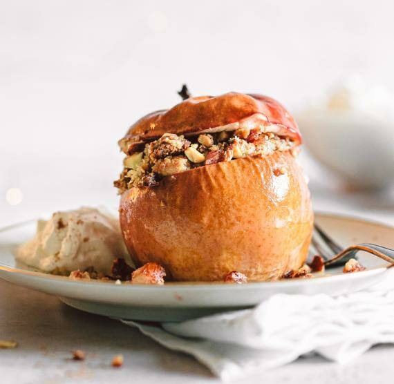 Mit Nüssen und Marzipan gefüllter Bratapfel auf weißem Teller