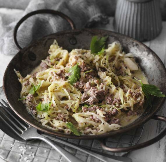 Pfanne mit Weißkohl und Hack in Sahnesauce, darüber Petersilie