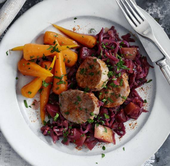 Schweinemedaillons mit Rotkohl und Karotten, darüber gehackte Petersilie