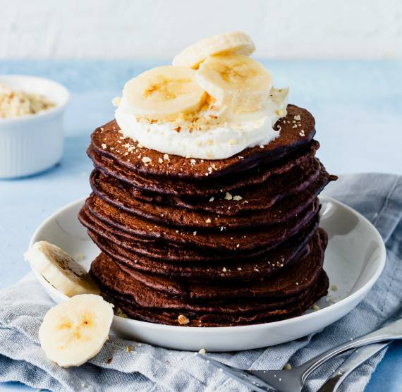 Gestapelte Schoko-Pancakes mit Sahne und Bananenscheiben