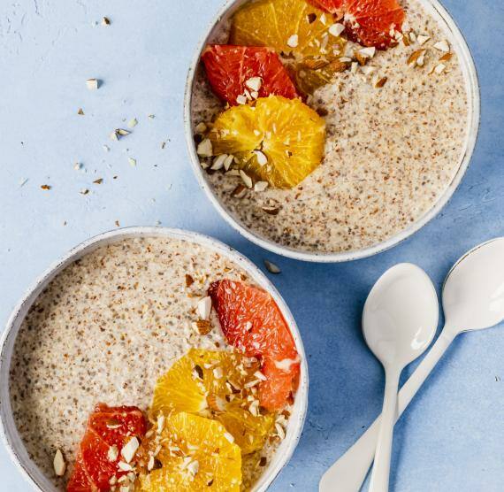 Zwei Schüsseln mit Porridge und Zitrusfrüchten