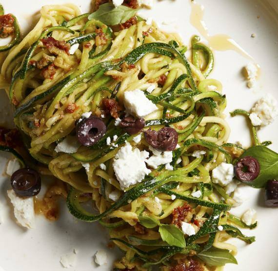 Gemüsenudeln aus Zucchini mit getrockneten Tomaten und Feta auf einem Teller