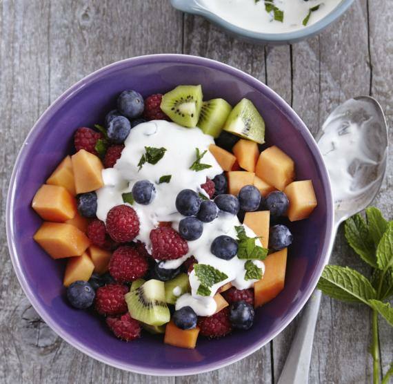 Schale mit gemischten Obstwürfeln auf einem Holztisch