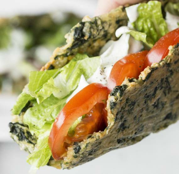 Taco mit Salatfüllung wird in der Hand gehalten