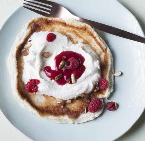 Pfannkuchen mit Sahne und Himbeeren auf einem Teller