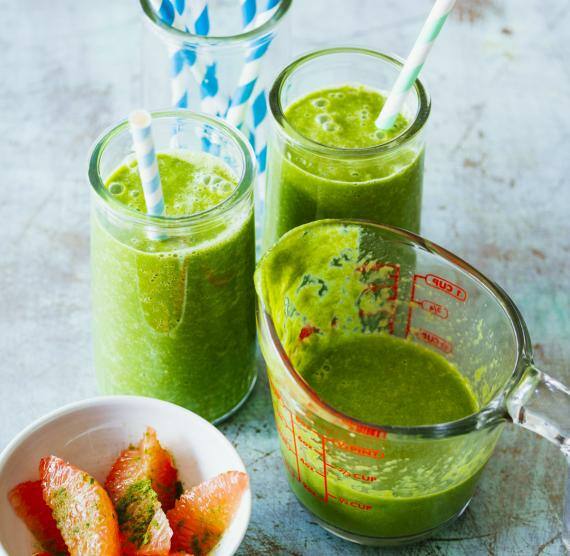 Grüner Smoothie in einem Glas mit Strohhalm