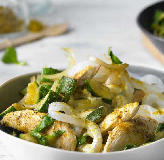 Hähnchenstücke, Konjanudeln, Zucchini und Pak Choi auf einem Teller