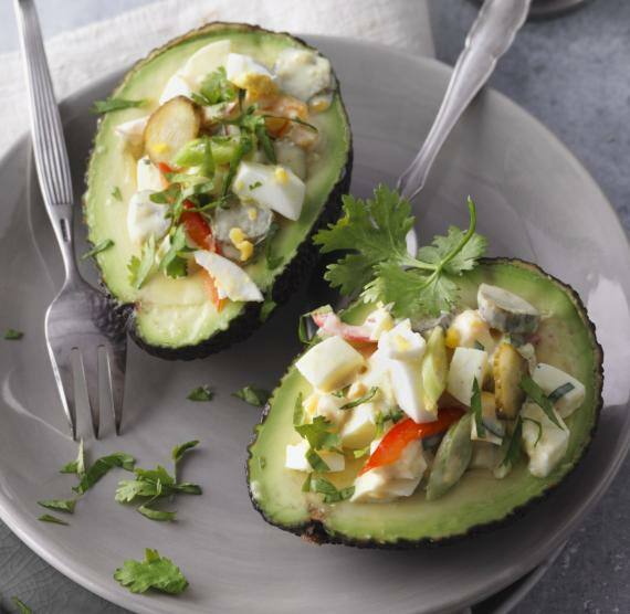 halbierte Avocado gefüllt mit Eiersalat auf einem Teller