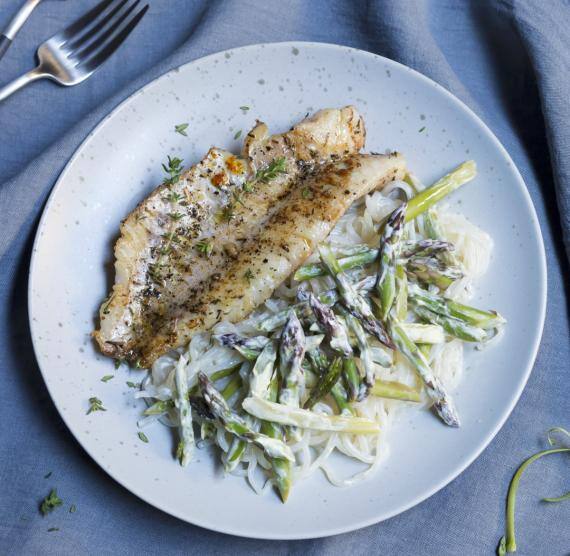 Grünes Spargel und Nudeln mit Fisch auf einem Teller
