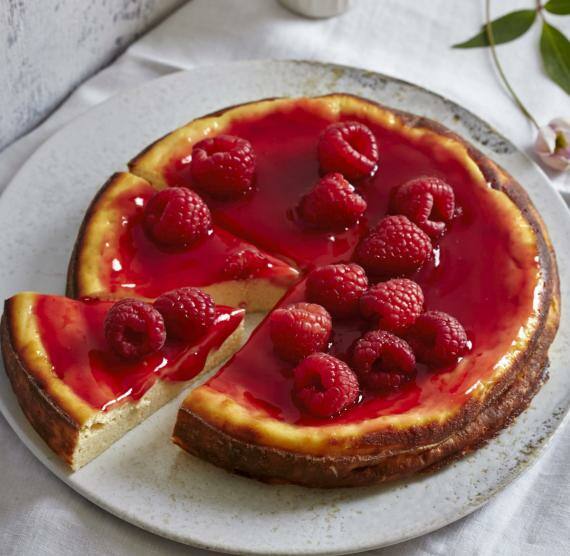 Käsekuchen mit Himbeeren auf einer Kuchenplatte
