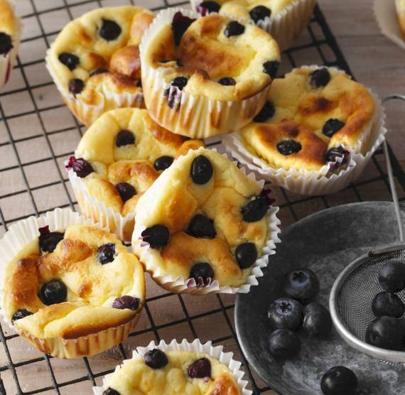Muffins mit Blaubeeren in Papierförmchen auf eine rustikalen Küchengitter
