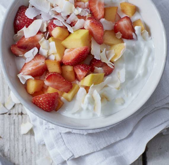 Quarkcreme mit Obstsalat und Kokoschips in einer Schale