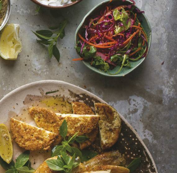 Mehere Schüsseln mit Salaten und Beilagen auf einem Steintisch