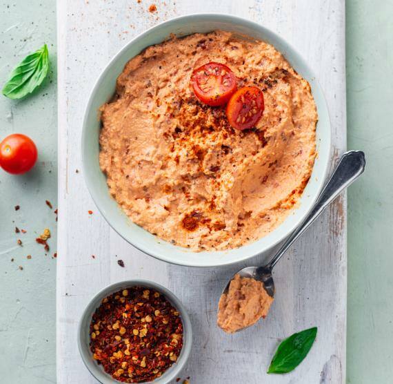 -Tomate‑Mozzarella‑Dip in einer Schale auf einem Holzbrett